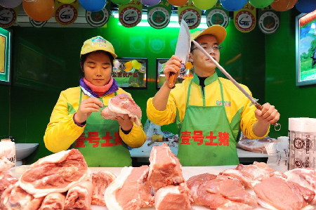 　2013年1月29日，上海天山路585弄澳華菜市場(chǎng)，江西財(cái)經(jīng)大學(xué)本科畢業(yè)生郝承兵（右）與海南大學(xué)本科生孫夏（左）在“壹號(hào)土豬”柜臺(tái)上工作。 