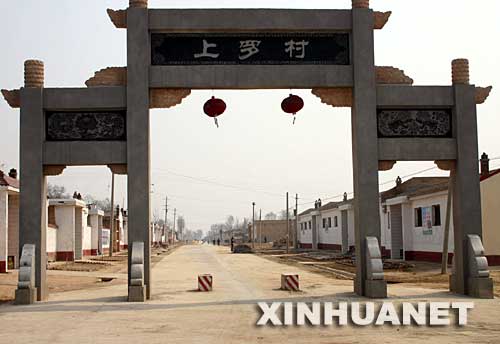 這是淳化縣胡家廟鄉(xiāng)新農(nóng)村“示范村”――上羅村村口的仿古門樓，政府為建門樓花費(fèi)8萬(wàn)多元（攝于3月5日）。 陜西省咸陽(yáng)市地處西部欠發(fā)達(dá)地區(qū)，目前尚未完全擺脫貧困，有的村民連吃水難、行路難問(wèn)題還沒(méi)有解決。然而，這里的一些鄉(xiāng)村熱衷于建廣場(chǎng)、立雕塑、修花壇、移大樹，花費(fèi)巨額資金“打造”新農(nóng)村“示范村”,還有的鄉(xiāng)村為了應(yīng)付領(lǐng)導(dǎo)參觀修遮羞墻、建仿古門，甚至毀良田、挖果園建新村。