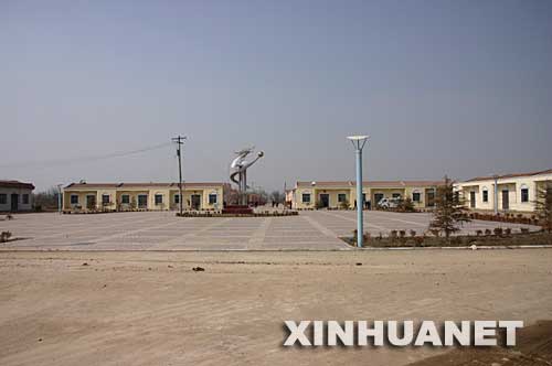 這是彬縣新民鎮(zhèn)新農(nóng)村“示范村”――東坡村新村中占地?cái)?shù)畝的廣場(chǎng)（攝于3月4日）。 陜西省咸陽(yáng)市地處西部欠發(fā)達(dá)地區(qū)，目前尚未完全擺脫貧困，有的村民連吃水難、行路難問(wèn)題還沒(méi)有解決。然而，這里的一些鄉(xiāng)村熱衷于建廣場(chǎng)、立雕塑、修花壇、移大樹，花費(fèi)巨額資金“打造”新農(nóng)村“示范村”,還有的鄉(xiāng)村為了應(yīng)付領(lǐng)導(dǎo)參觀修遮羞墻、建仿古門，甚至毀良田、挖果園建新村。 