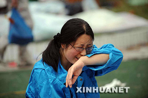 5月14日，張關(guān)蓉在丈夫譚千秋的遺體旁痛哭。 受汶川地震影響，四川省德陽(yáng)市東汽中學(xué)教學(xué)樓坍塌。在地震發(fā)生的一瞬間，該校教導(dǎo)主任譚千秋雙臂張開(kāi)趴在課桌上，身下死死地護(hù)著4個(gè)學(xué)生，4個(gè)學(xué)生都獲救了，譚老師卻不幸遇難。 新華社記者王建華攝 