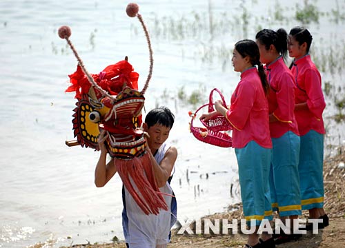 6月2日，一名龍舟隊員正在汨羅江邊祭龍頭。 當日，“我們的節(jié)日·端午節(jié)”主題文化活動暨第三屆中國汨羅江國際龍舟邀請賽在湖南汨羅市舉行。來自澳大利亞、荷蘭以及中國各地的十幾支龍舟隊在汨羅江參加角逐。汨羅是中國古代偉大詩人屈原晚年生活、創(chuàng)作和投江殉國之地。 新華社記者 李尕 攝 