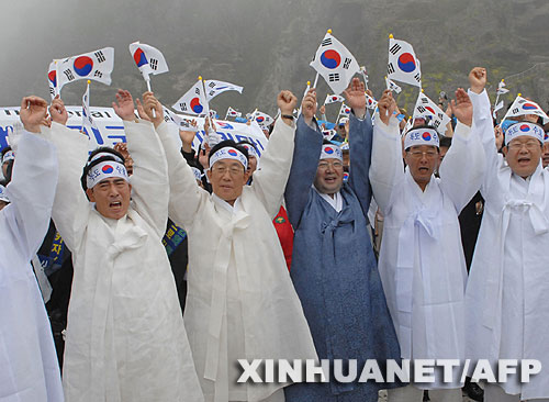 7月14日，大批韓國人在獨島（日本稱“竹島”）手舉國旗抗議。韓國外交通商部發(fā)言人文太暎當日發(fā)表聲明，強烈抗議日本在當天公布的中學教科書指導手冊中將獨島（日本稱“竹島”）表述為日本領(lǐng)土，并要求日本立即對有關(guān)內(nèi)容進行修正。韓國外交通商部將采取召回韓國駐日本大使和召見日本駐韓國大使這兩項外交措施，就此問題向日本政府表示強烈抗議。 新華社/法新 