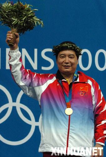 2004年8月14日，王義夫獲第28屆雅典奧運會射擊男子10米氣手槍金牌。圖為王義夫在領獎臺上向觀眾致意。 