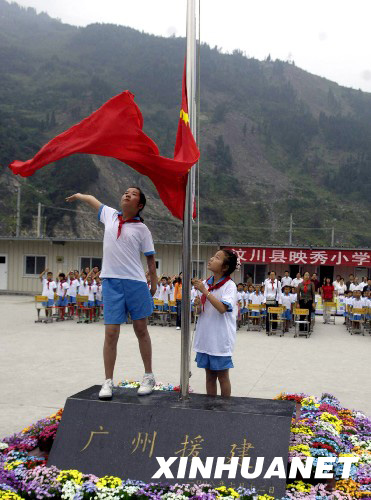 8月27日，映秀小學學生在板房校園內升起鮮艷的五星紅旗。 新華社發(fā)