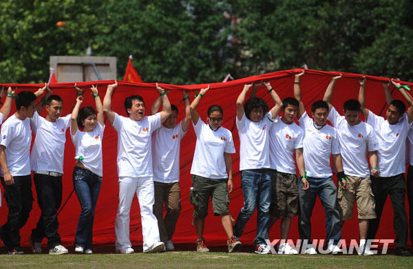  5月11日，成龍等和北川師生共擎巨幅國旗。