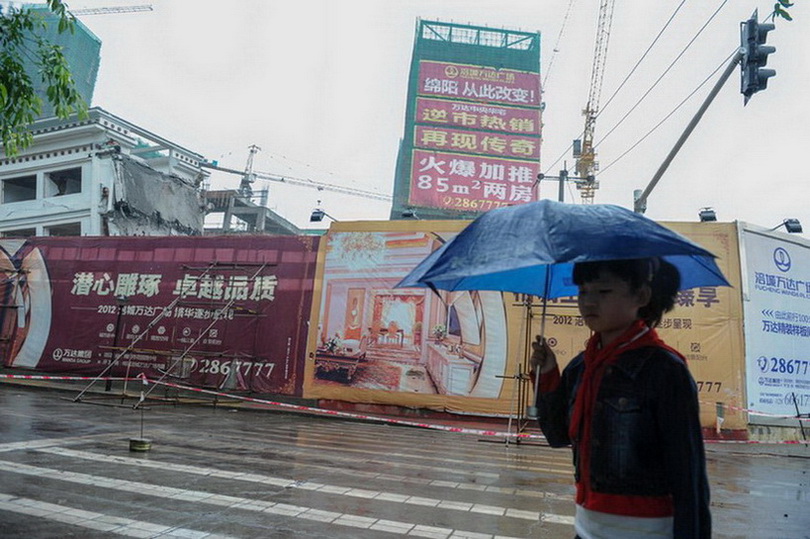 5月21日，一名小學生從拆遷現(xiàn)場附近街道走過。新華社記者 李橋橋 攝  