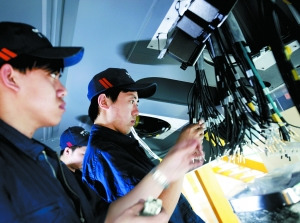 中國(guó)北車長(zhǎng)春CRH380B生產(chǎn)車間　車廂底部，工人們正安裝線纜。動(dòng)車制造過程實(shí)行嚴(yán)格的質(zhì)量管理措施，每個(gè)工序、環(huán)節(jié)、零件都是實(shí)名制。（圖片來源：新京報(bào)）