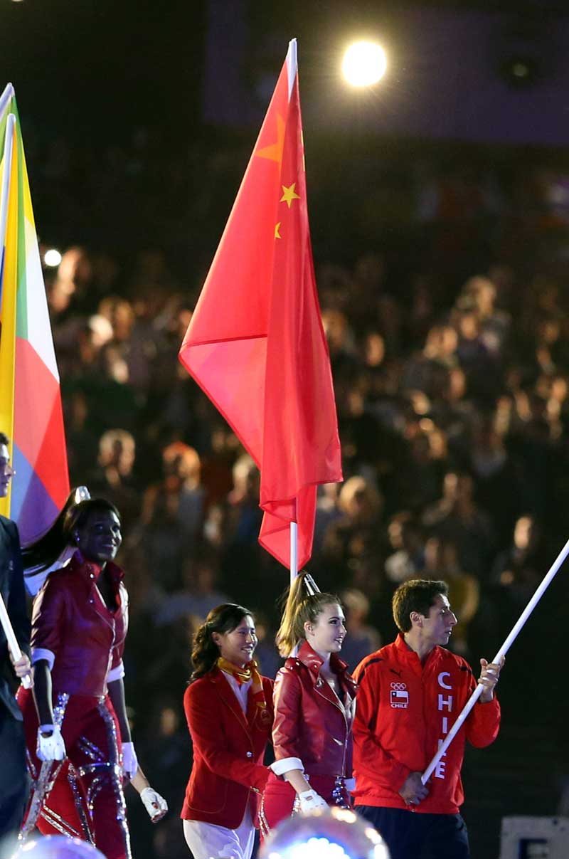 這是中國(guó)代表團(tuán)旗手、奧運(yùn)會(huì)女子激光雷迪爾級(jí)冠軍徐莉佳（右三）在閉幕式上高舉五星紅旗入場(chǎng)。 攝影： 新華社記者  凡軍