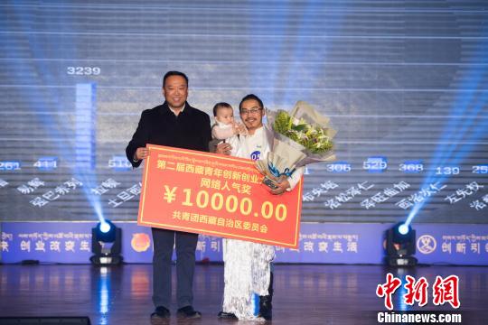 圖為強巴(右一)的本土文化創(chuàng)意項目獲得網(wǎng)絡人氣獎。　何蓬磊 攝